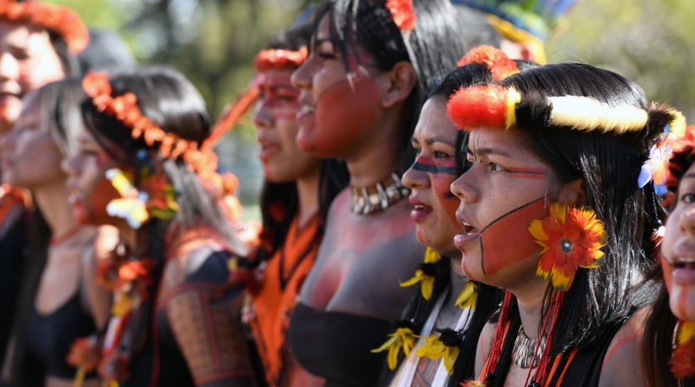 Fiatal őslakos nők tollakkal díszítve