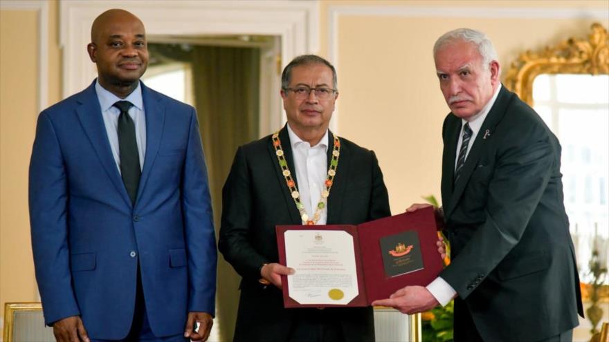 Riad al-Maliki palesztin külügyminiszter (jobbra) kitünteti Gustavo Petro kolumbiai elnököt (középen) a Palesztin Nagygallérral Bogotában