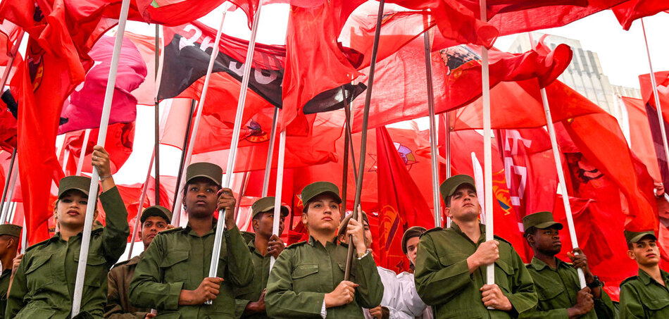 A kubai fegyveres erők tagjai vörös zászlókkal és a „Július 26-i Mozgalom” zászlajával vonulnak az Egyesült Államok havannai nagykövetsége előtt, hogy tiltakozzanak a január 3-i venezuelai támadás és Nicolás Maduro elnök és felesége, Cilia Flores elrablása ellen